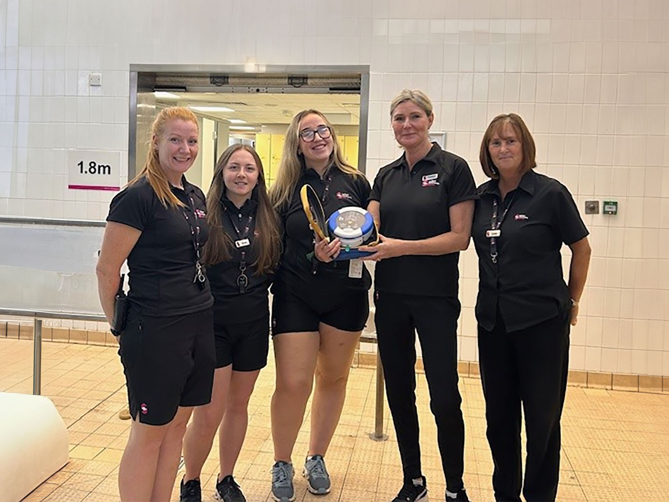 A group of staff from Salford Community Leisure with one of the new defibrillators