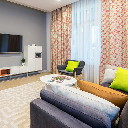 A living room with sofa, armchair and TV