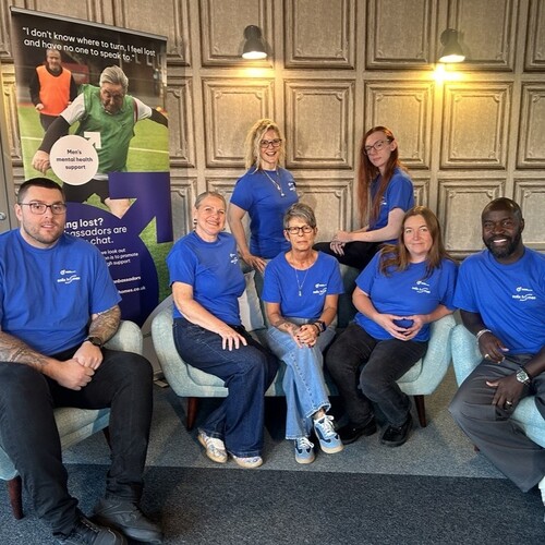 A group of staff wearing blue Salford Manbassadors t-shirts