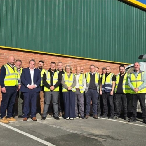 A group of tradespeople outside a new repairs hub building