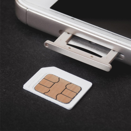 A SIM card beside a mobile phone