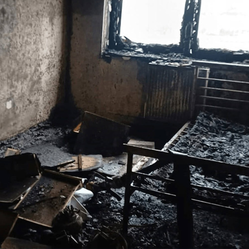 A bedroom blackened and burnt out by a fire, caused by a faulty e-bike charger