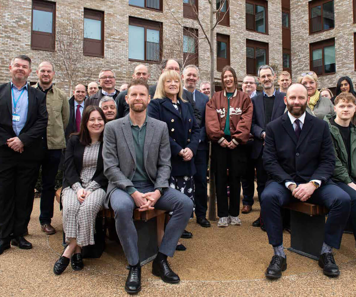 A large group of people outside a brand new block of flats