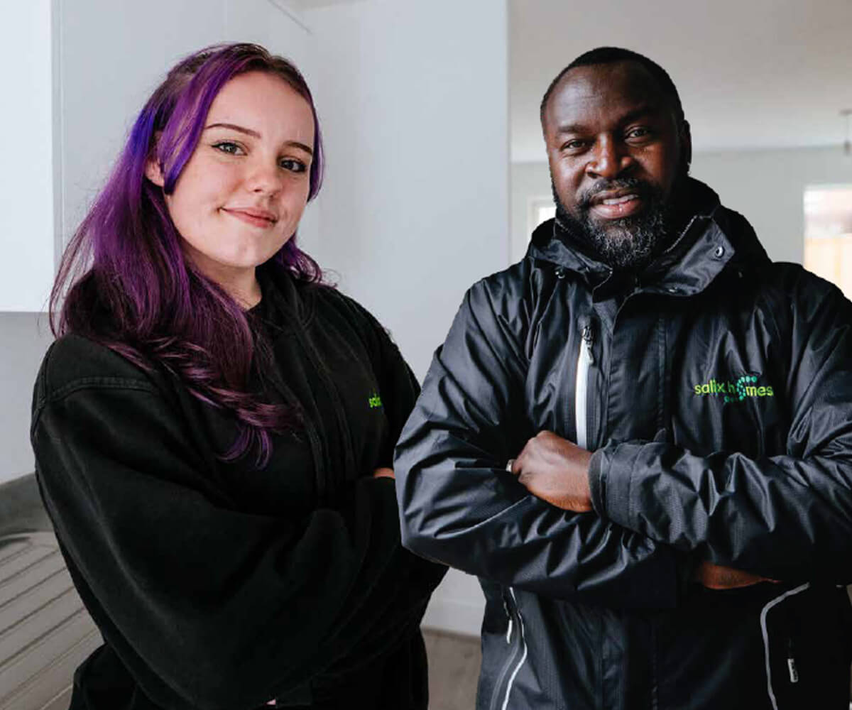 Two people in Salix Homes uniforms, stood with their arms folded