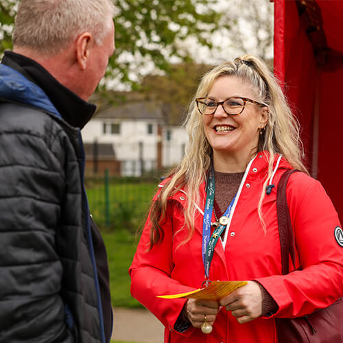 A smiling woman having a conversation with a man