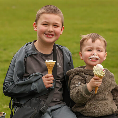 Two young boys eating ice creams