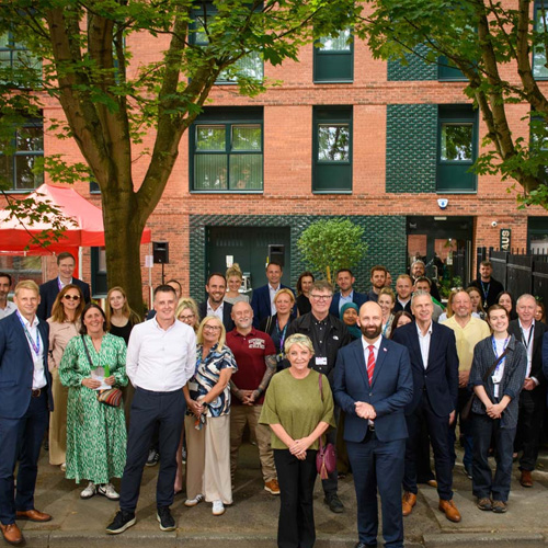 A large group of people stood outside Willohaus, a new-build block of apartments in Salford